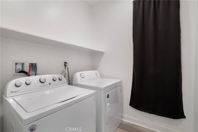 washroom featuring light hardwood / wood-style flooring and washing machine and dryer