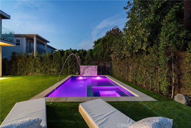 view of pool with pool water feature, a yard, and an in ground hot tub