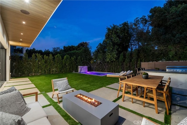 patio terrace at dusk with an outdoor fire pit and a swimming pool