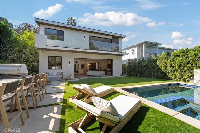 rear view of property with a yard, outdoor lounge area, and a patio