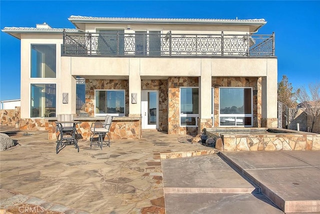 27008 Reef Ln, Helendale, CA 92342 - rear view of property with a balcony, stone siding, a patio, and stucco siding