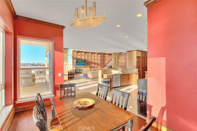 dining room featuring sink, crown molding, and hardwood / wood-style floors