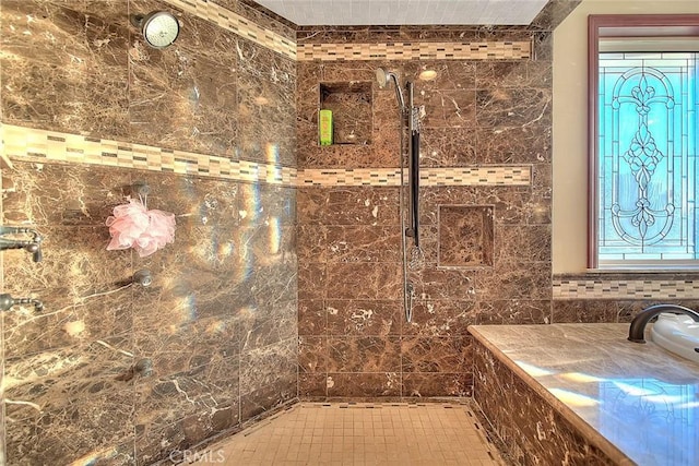 bathroom featuring a shower, plenty of natural light, and tile walls