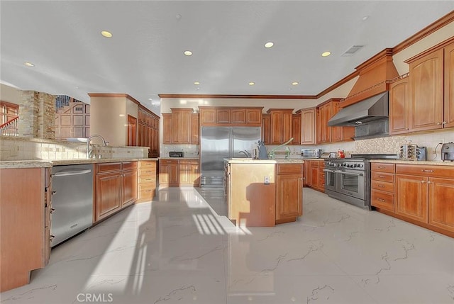 kitchen featuring backsplash, an island with sink, ornamental molding, wall chimney exhaust hood, and high quality appliances