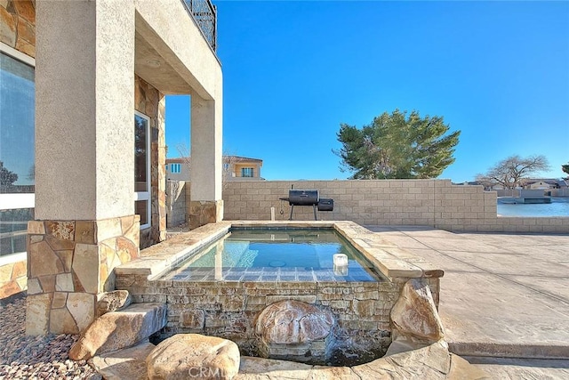 view of swimming pool featuring a jacuzzi and a patio