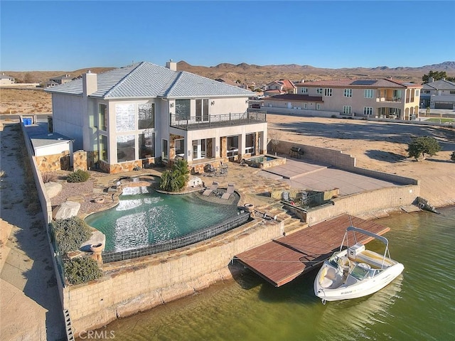 rear view of house with a balcony and a water and mountain view