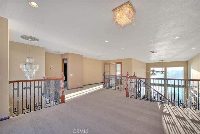 hallway with carpet and a chandelier