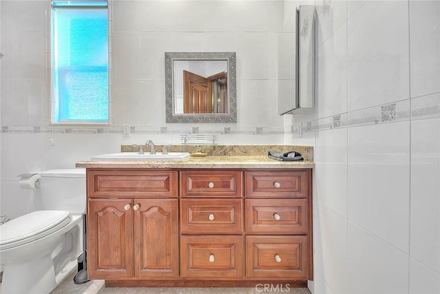 bathroom featuring tile walls, toilet, and vanity