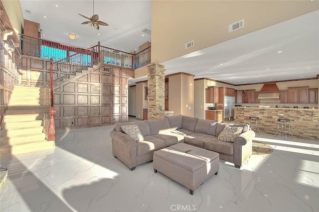 27008 Reef Ln, Helendale, CA 92342 - living room with marble tiled floors, ornate columns, a ceiling fan, a towering ceiling, and stairs