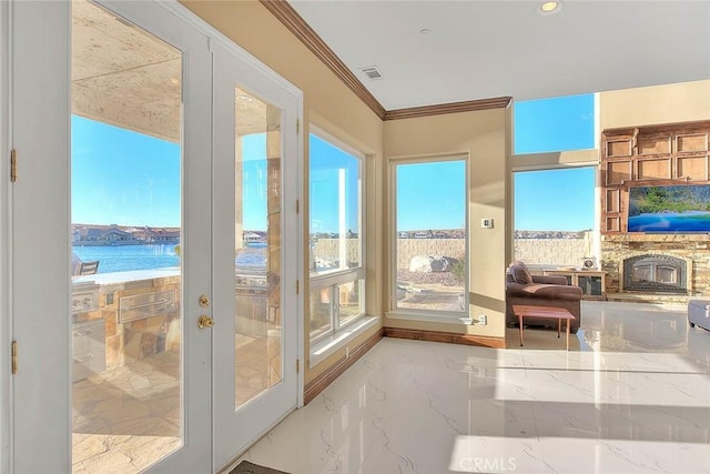 entryway with a wealth of natural light, a water view, and french doors