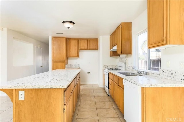 kitchen with light tile patterned floors, a center island, white appliances, light stone counters, and sink