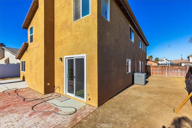 rear view of house featuring cooling unit and a patio