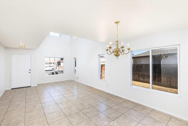 empty room featuring an inviting chandelier, light tile patterned floors, and lofted ceiling