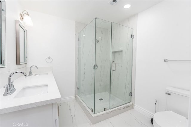 bathroom featuring toilet, a shower with shower door, and vanity