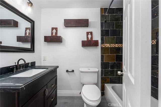 full bathroom featuring toilet, tiled shower / bath combo, hardwood / wood-style flooring, and vanity