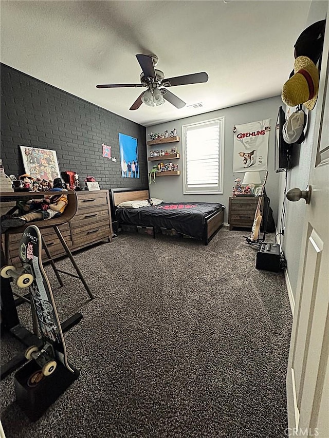 bedroom featuring ceiling fan and brick wall