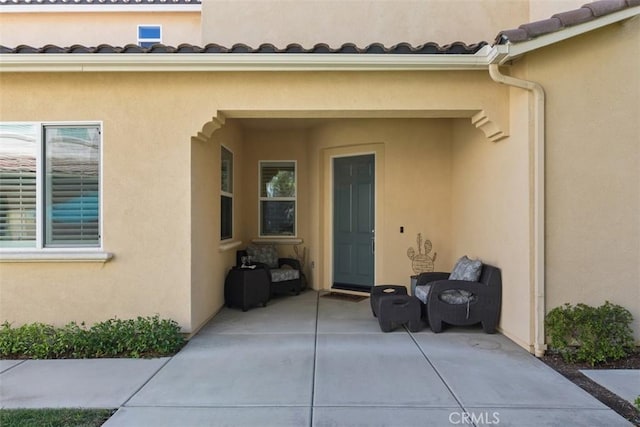 view of exterior entry featuring a patio area