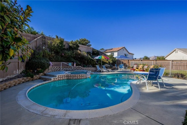 view of swimming pool featuring an in ground hot tub and a patio