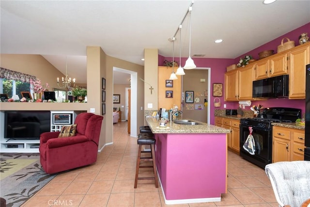 kitchen featuring an inviting chandelier, a kitchen bar, hanging light fixtures, black appliances, and sink