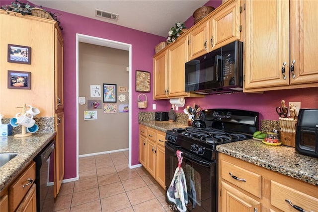 kitchen with light tile patterned floors, light stone counters, and black appliances