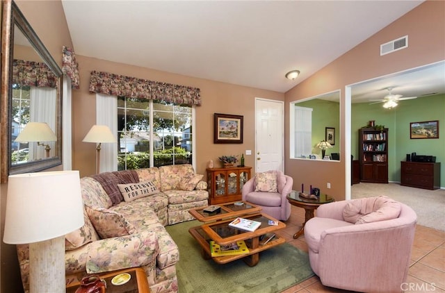 tiled living room with ceiling fan and vaulted ceiling