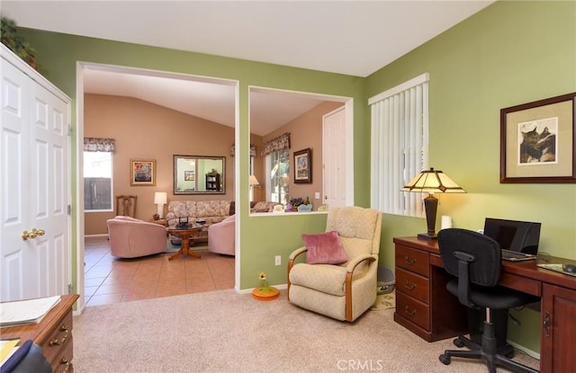 tiled office space featuring vaulted ceiling