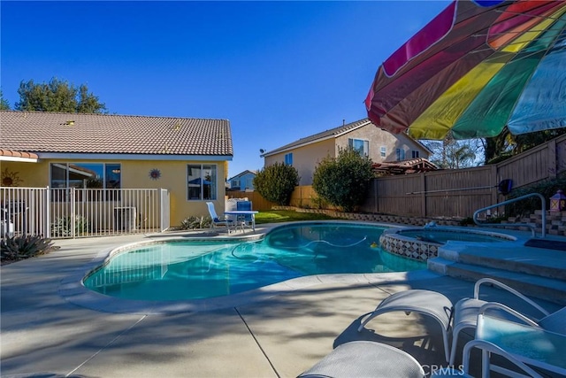 view of swimming pool featuring a patio area and an in ground hot tub