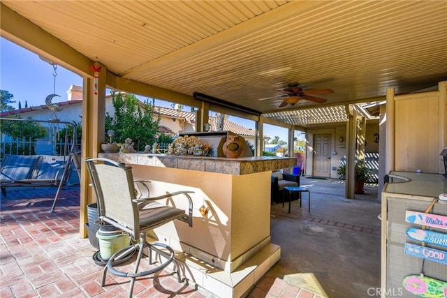 view of patio / terrace with ceiling fan and an outdoor bar