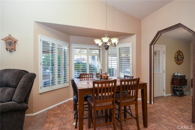 dining room with tile patterned flooring, vaulted ceiling, and an inviting chandelier