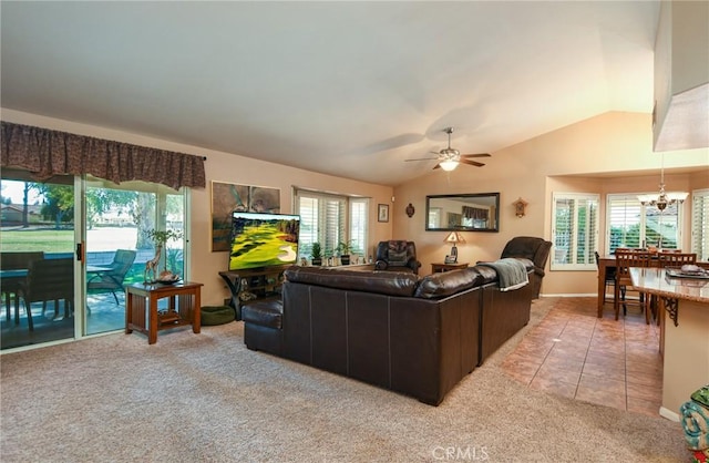 living room with ceiling fan with notable chandelier, light colored carpet, and vaulted ceiling