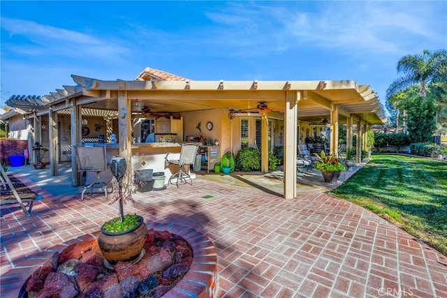 view of patio featuring ceiling fan and a bar