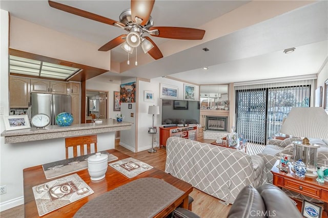 living room featuring ceiling fan and light wood-type flooring