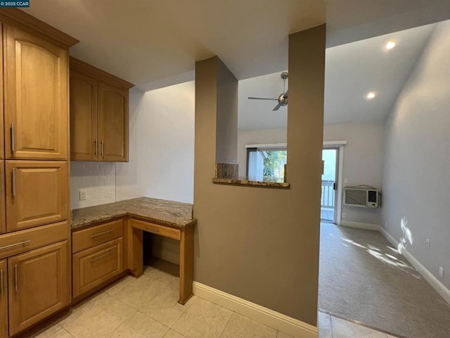 kitchen featuring light carpet, backsplash, a wall mounted AC, ceiling fan, and stone counters