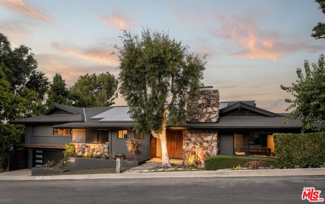 view of front of property featuring solar panels