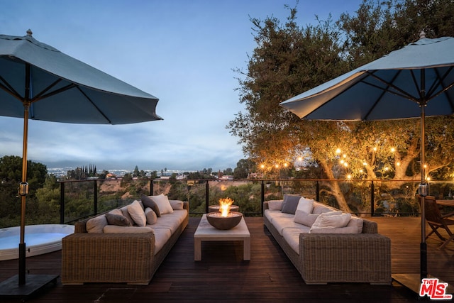 deck at dusk with an outdoor living space with a fire pit