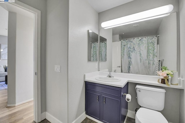 bathroom with toilet, vanity, a shower with curtain, and hardwood / wood-style floors