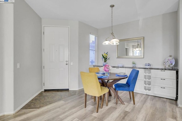 dining room with a notable chandelier and light wood-type flooring