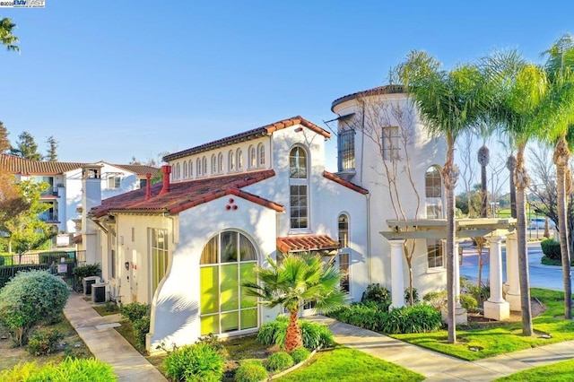 mediterranean / spanish home featuring a pergola and central AC