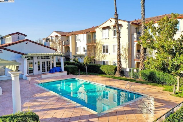 view of pool with an outdoor structure, french doors, and a patio