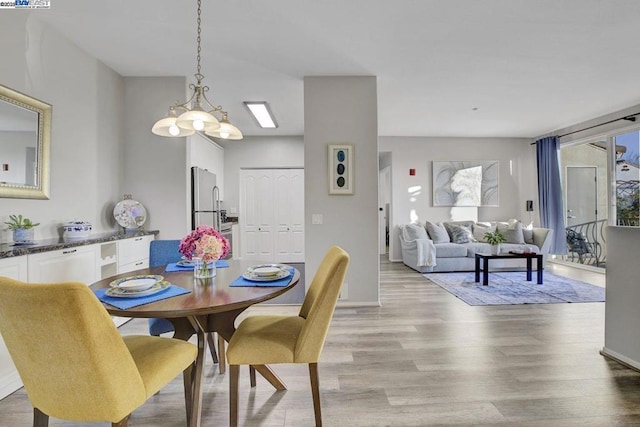 dining room featuring light hardwood / wood-style flooring, a notable chandelier, and expansive windows