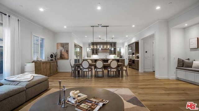 living room with crown molding and light hardwood / wood-style flooring