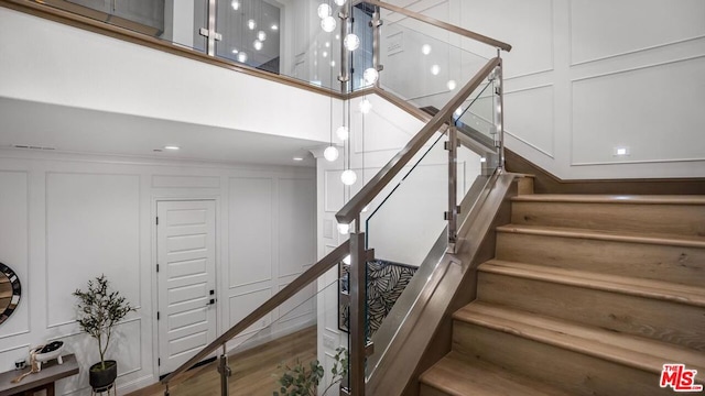 staircase featuring a high ceiling and hardwood / wood-style flooring