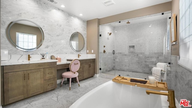 bathroom featuring separate shower and tub, vanity, and tile walls