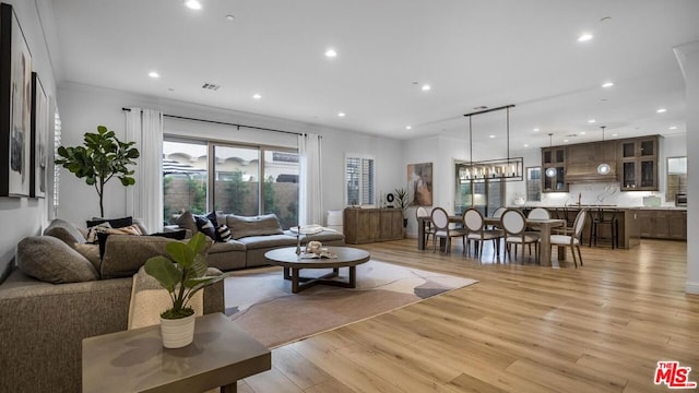 living room with light hardwood / wood-style floors and ornamental molding