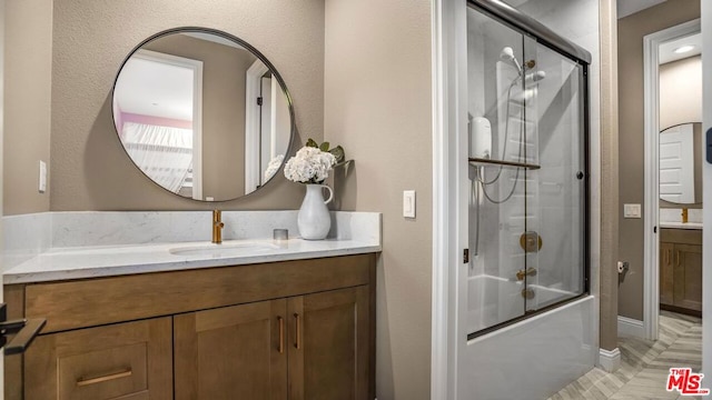 bathroom featuring tile patterned floors, combined bath / shower with glass door, and vanity