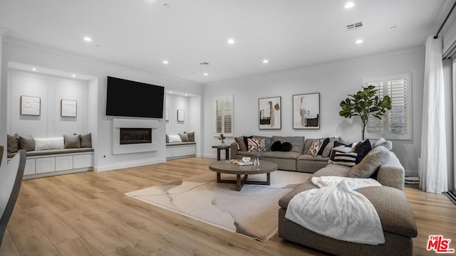 living room featuring crown molding and light hardwood / wood-style flooring