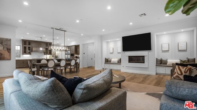 living room featuring light hardwood / wood-style flooring and ornamental molding