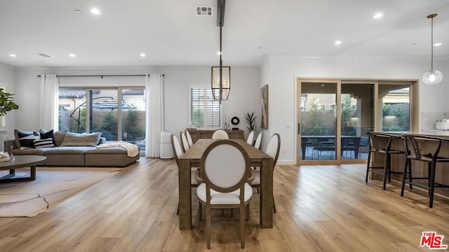 dining room with light hardwood / wood-style flooring and crown molding