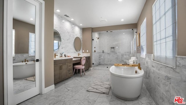 bathroom featuring vanity, tile walls, and shower with separate bathtub