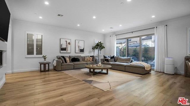 living room with crown molding and light hardwood / wood-style floors